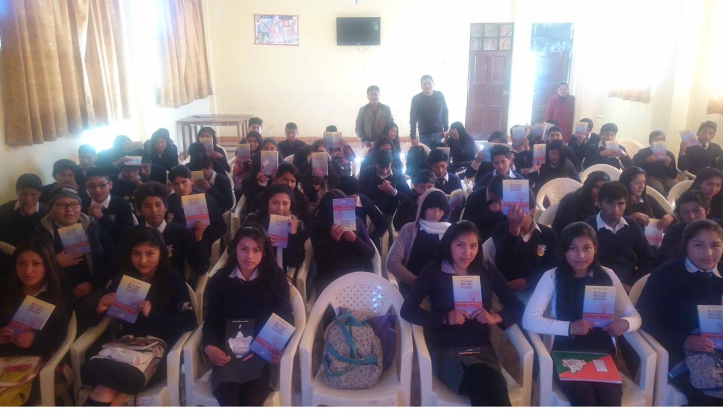 Estudiantes de colegio sosteniendo copias de El Árbol que Llora Sangre