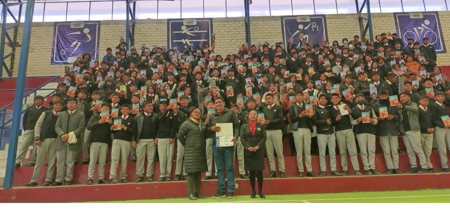 Hundreds of students holding books by David Vildoso in a stadium